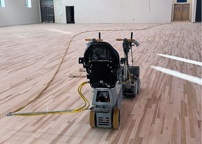 a sanding machine sites on a hardwood floor