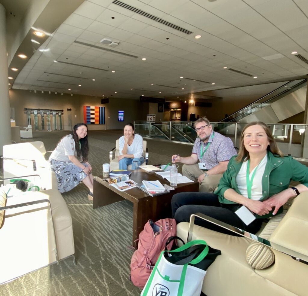 SPS teachers posing at journalism convention sitting on chairs in lobby conference