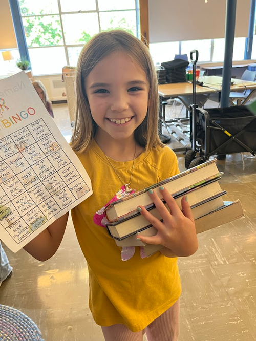 Alki student holding their summer reading bingo card