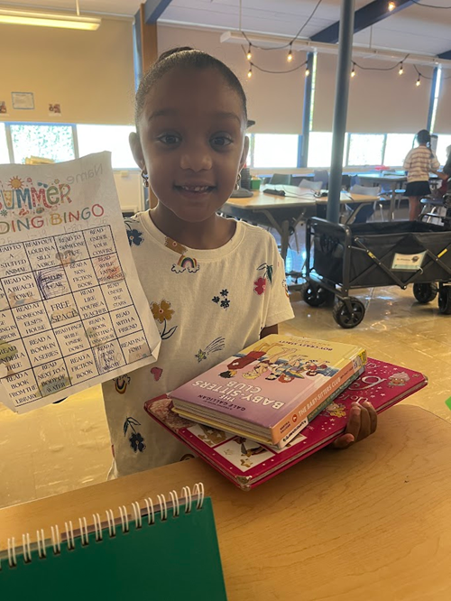 Alki student holding their summer reading bingo card
