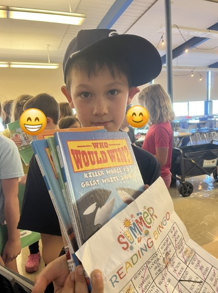 Alki student holding their summer reading bingo card