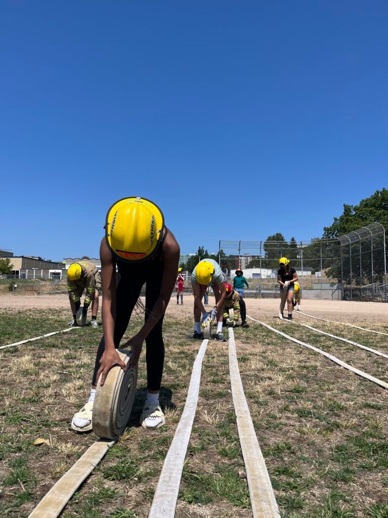 students rolling up fire hydrants in career exploration class