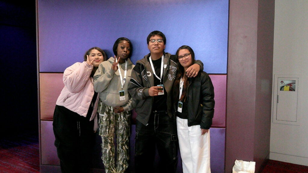 students posing in front of blue and pink backgorund