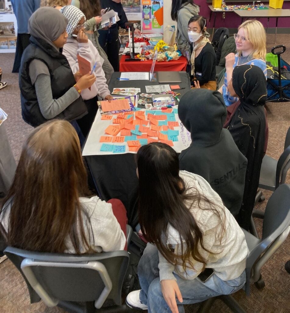 students gathered around table at resource fair