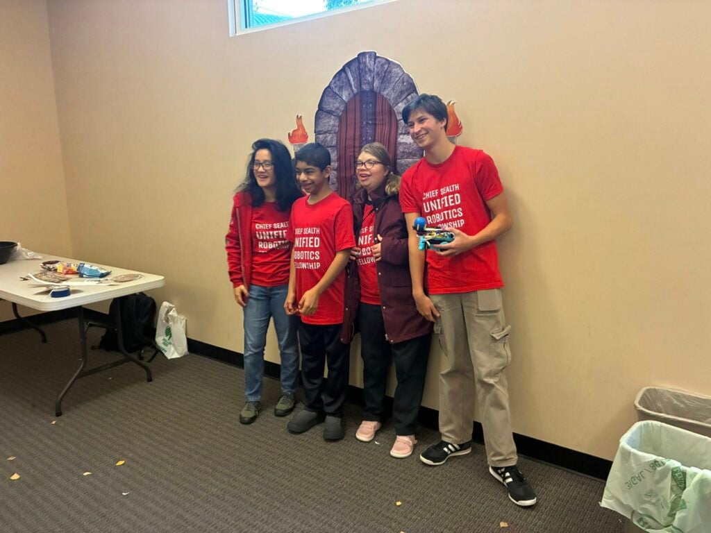 high school students posing with robots