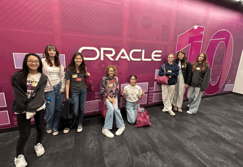 students standing in front of pink oracle sign on STEAM field trip