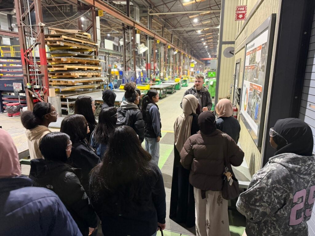 students on shop floor listening to presenter