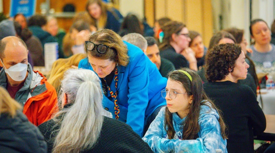 SPS staff member, Marni Campbell, speaking to community members and writing down key points on a poster board at Eckstein Middle School March 17, 2026 community meeting