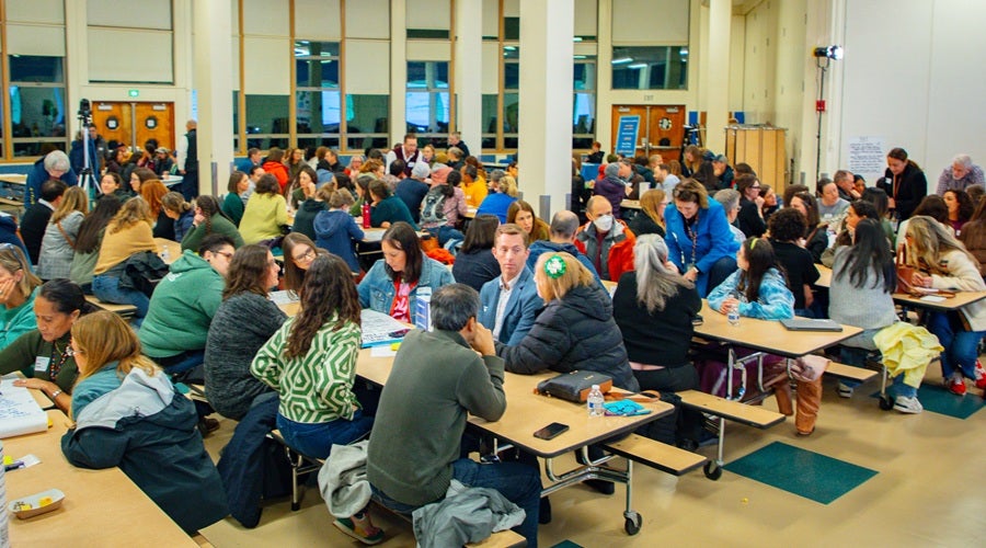 Community members sitting at tables in Eckstein Middle School March 17, 2026 community meeting