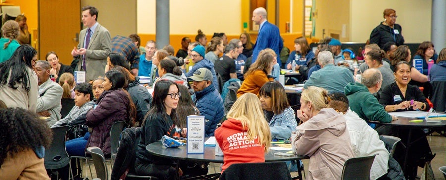 Community members sitting at tables in South Shore Prek-8 School March 3, 2026 community meeting.