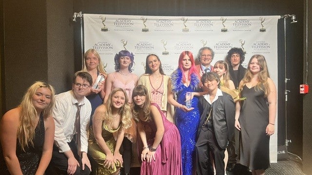 group photo of students posing and smiiling in fofrmal wear