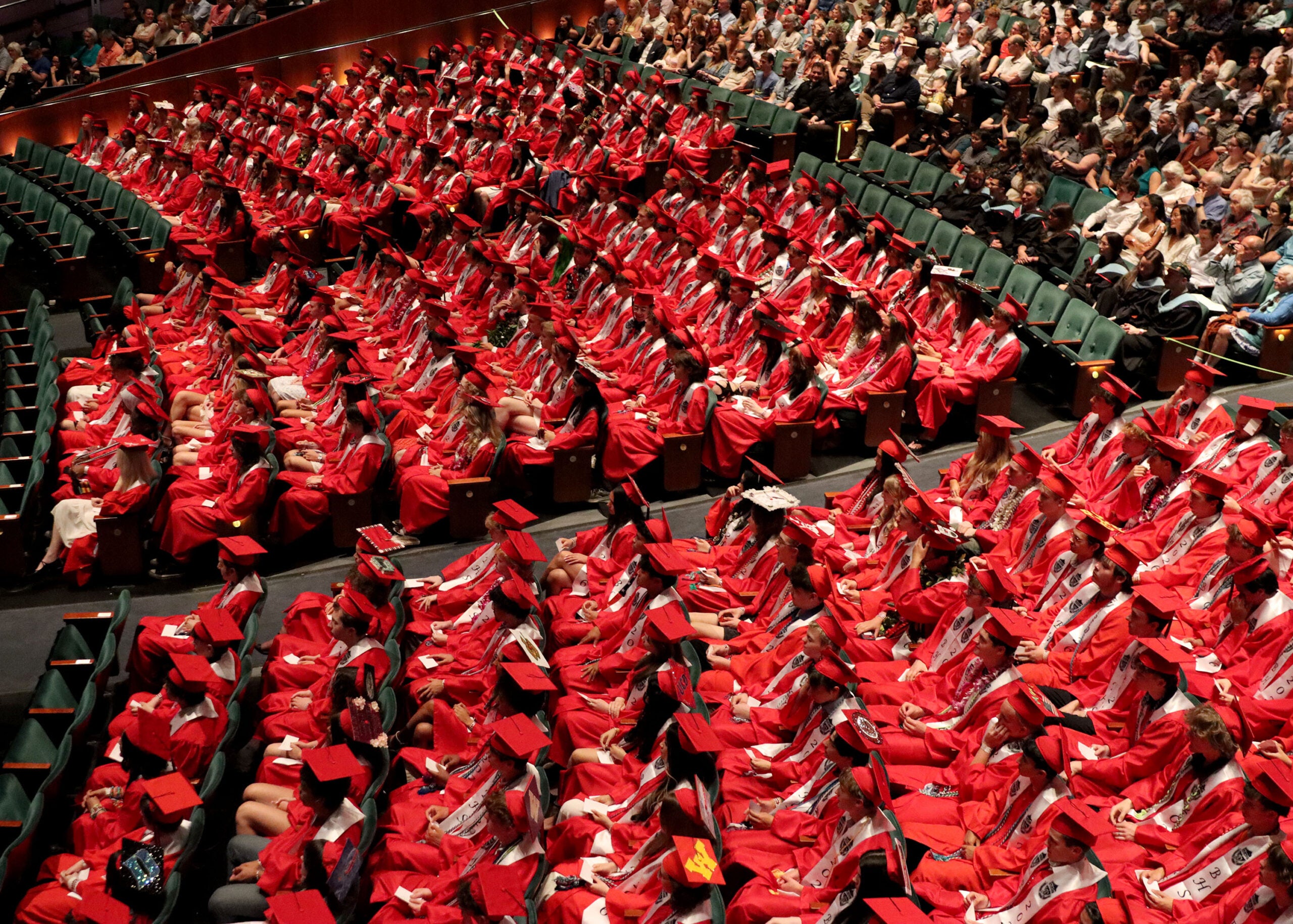 Graduation Ballard a sea of students in the audience in red cap and gowns