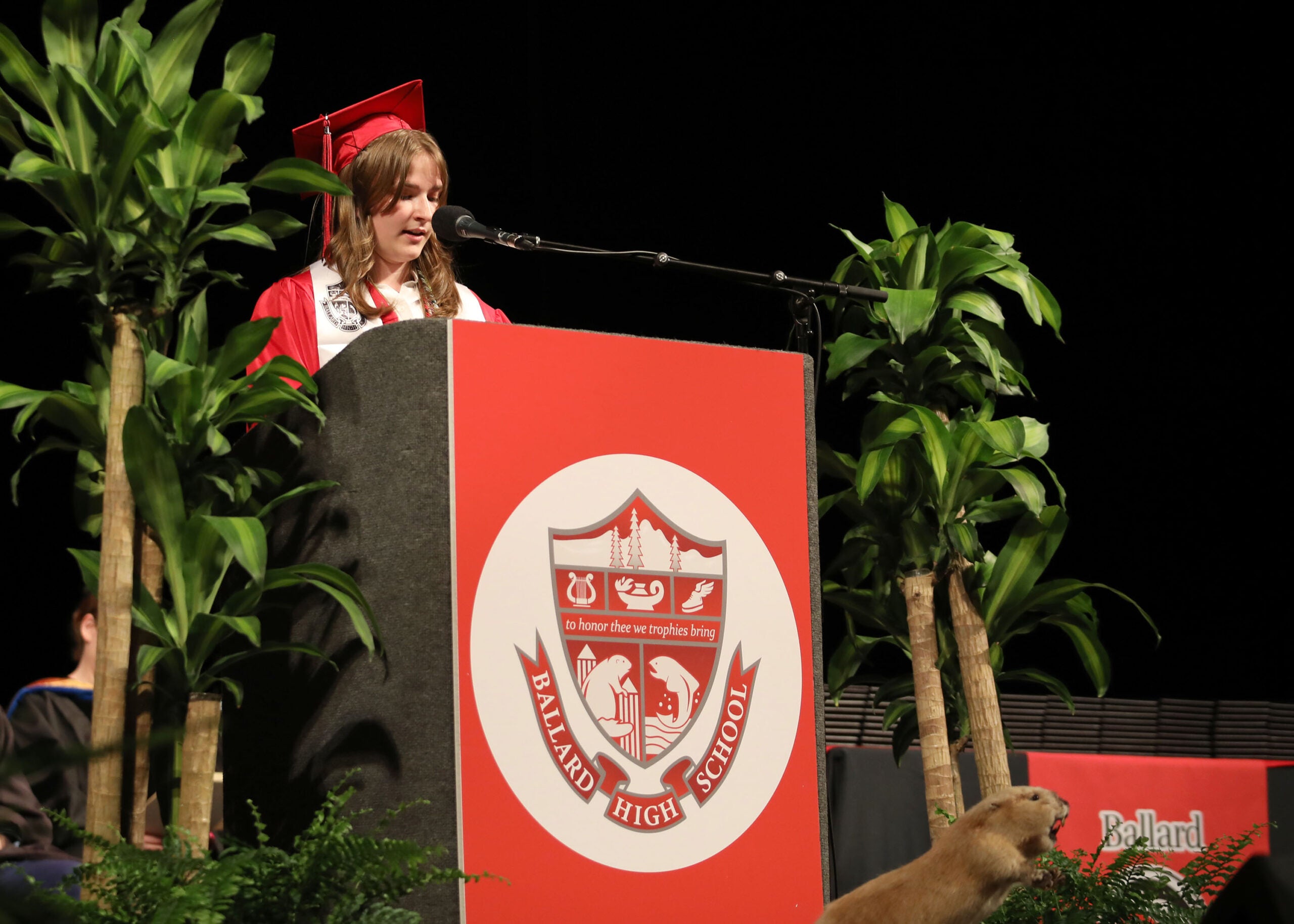 Graduation Ballard student in cap and gown speaking at the podium