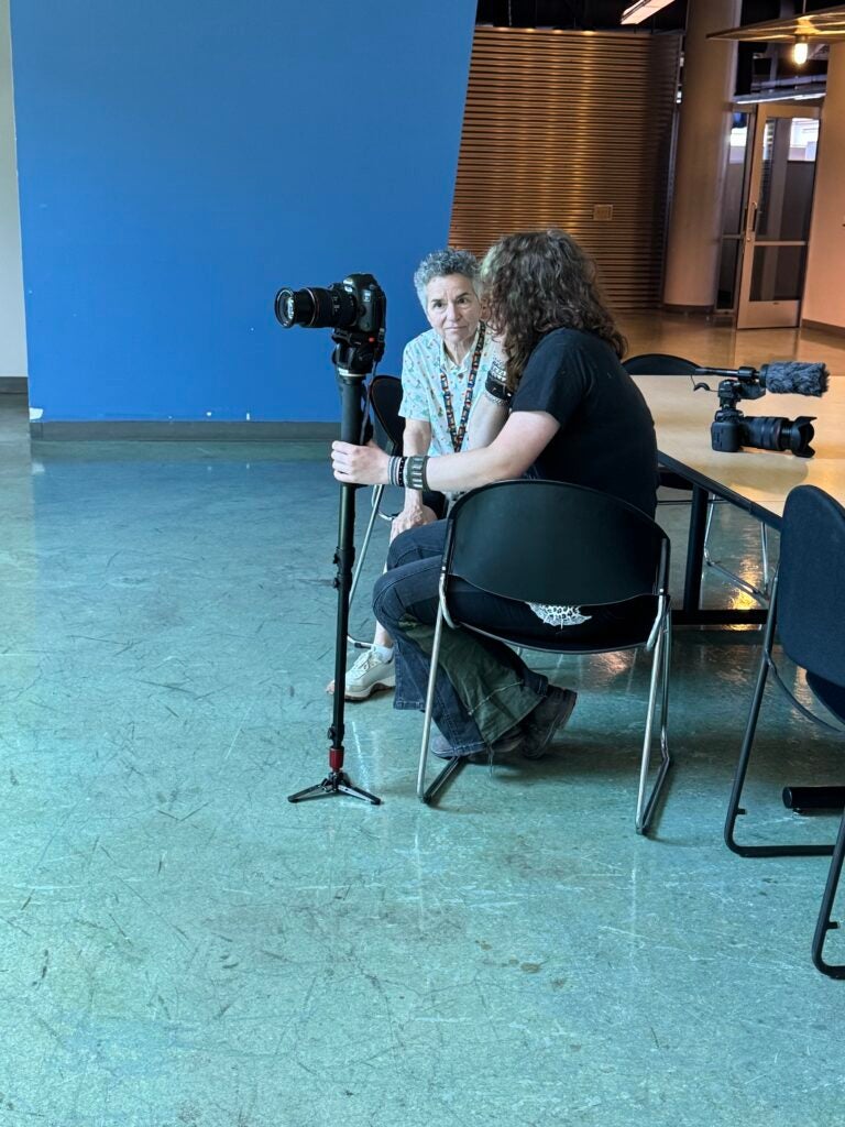 student managing a camera with mentor