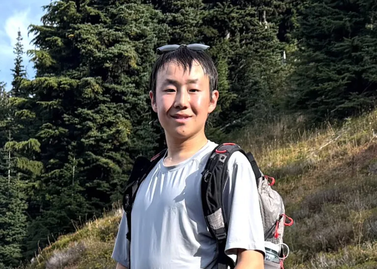 Student on a hike in front of the a mountain