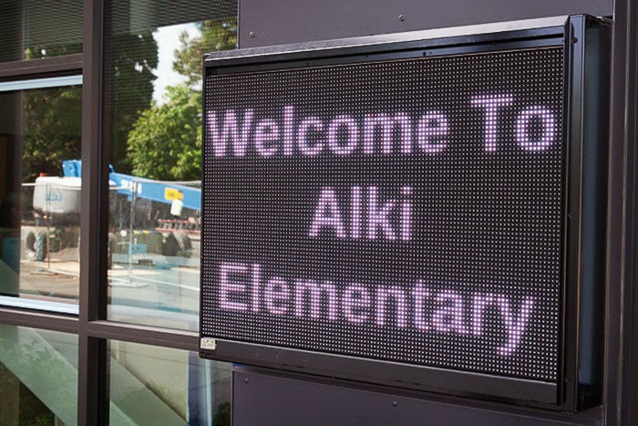 a digital sign that says Welcome to Alki Elementary