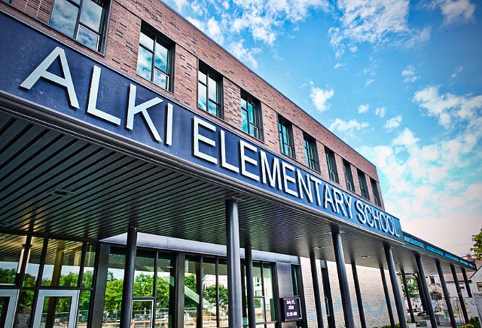 a brick building with a large sign across the awning that says Alki Elementary