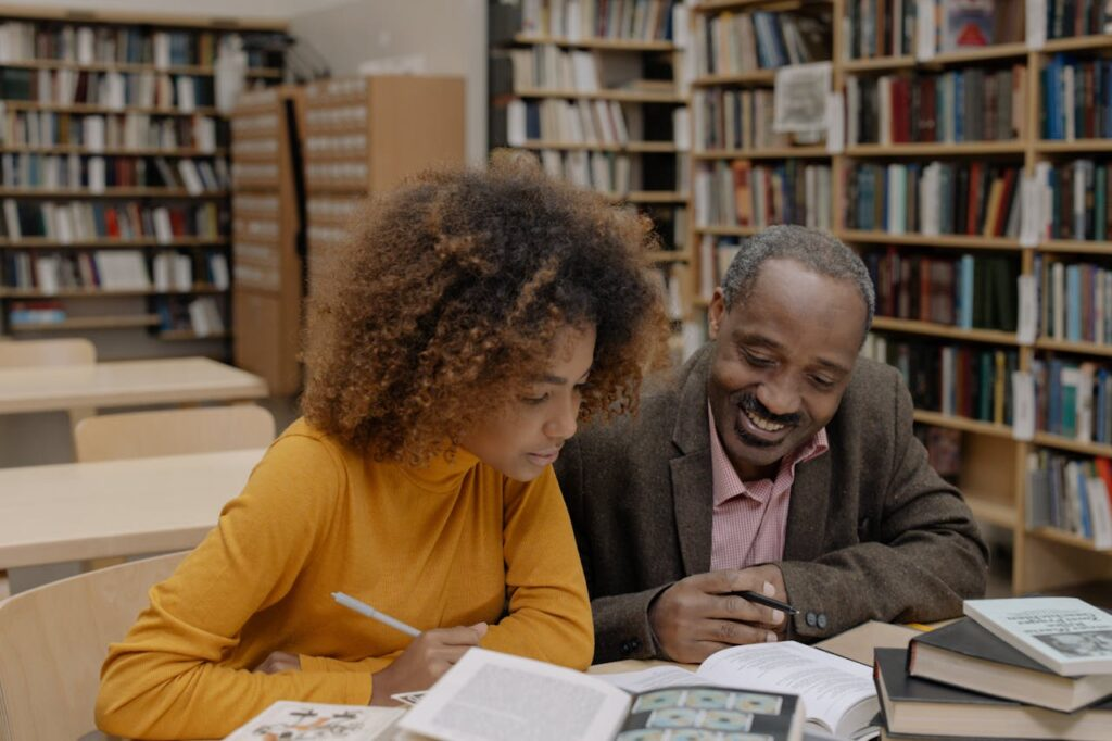 photo from litiarts website of two people reading books in what appears to be a library
