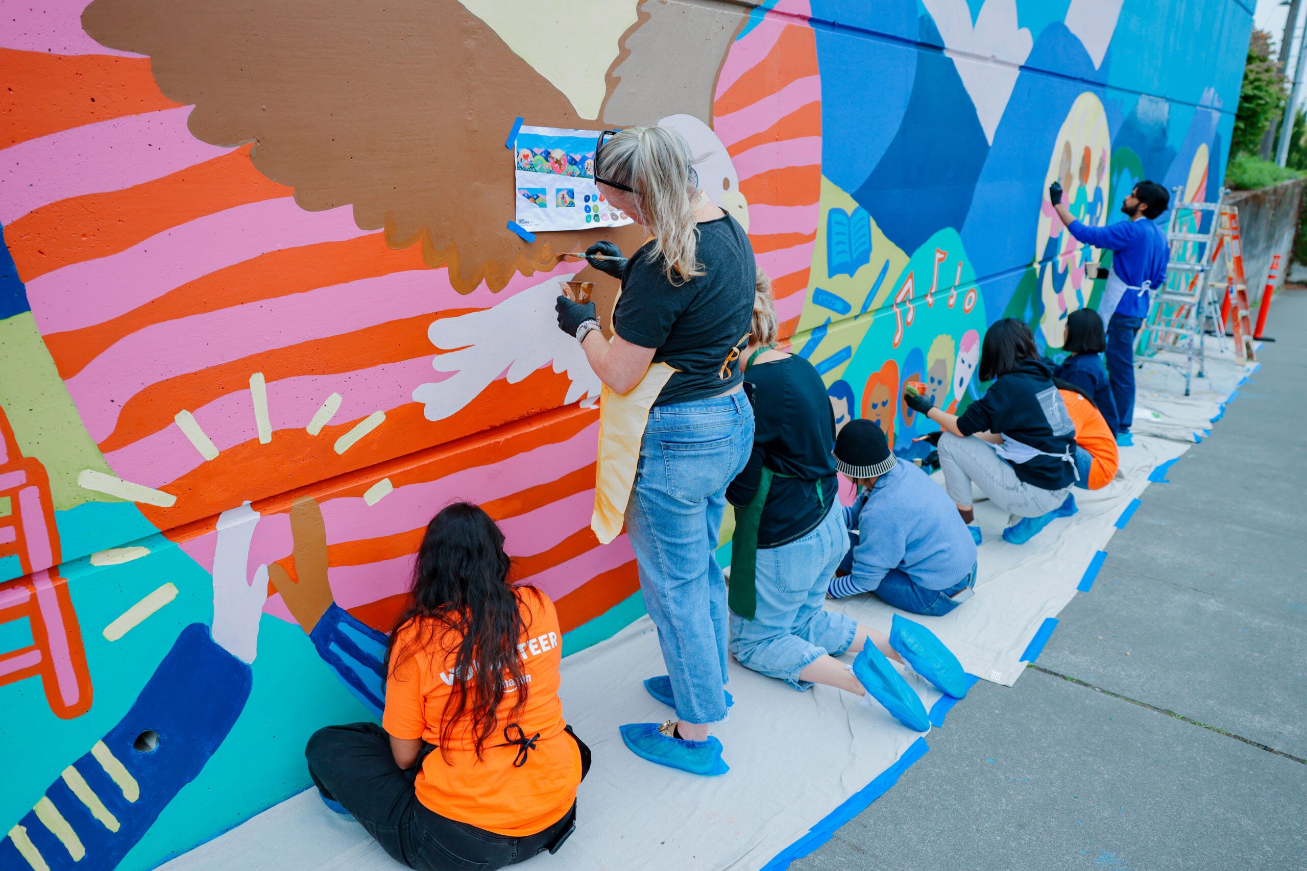students and an adult painting the Emerson mural