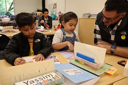 Lowell Students and an adult reading together