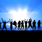 silhouette of students jumping in the air in front of a sunset