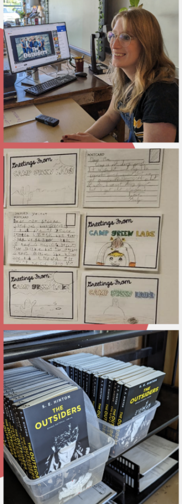 Teacher at computer, books and Notes on a classroom wall.