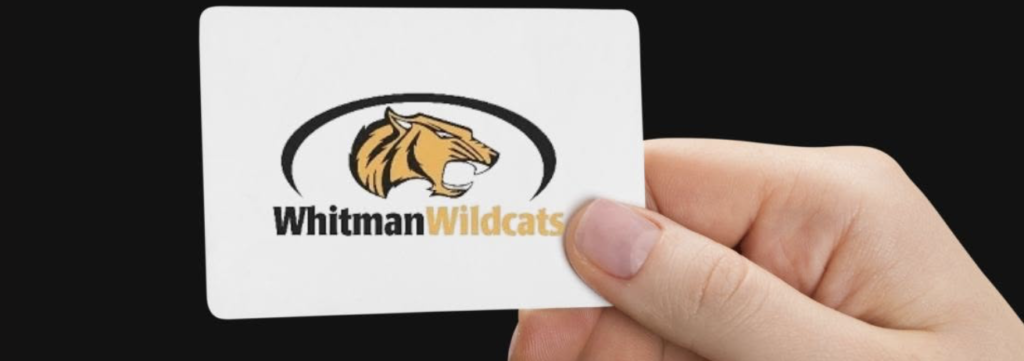 Wildcat on card with part of a hand. Text: Whitman Wildcat
