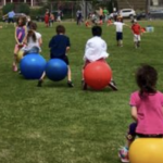Field with students on large bouncy balls