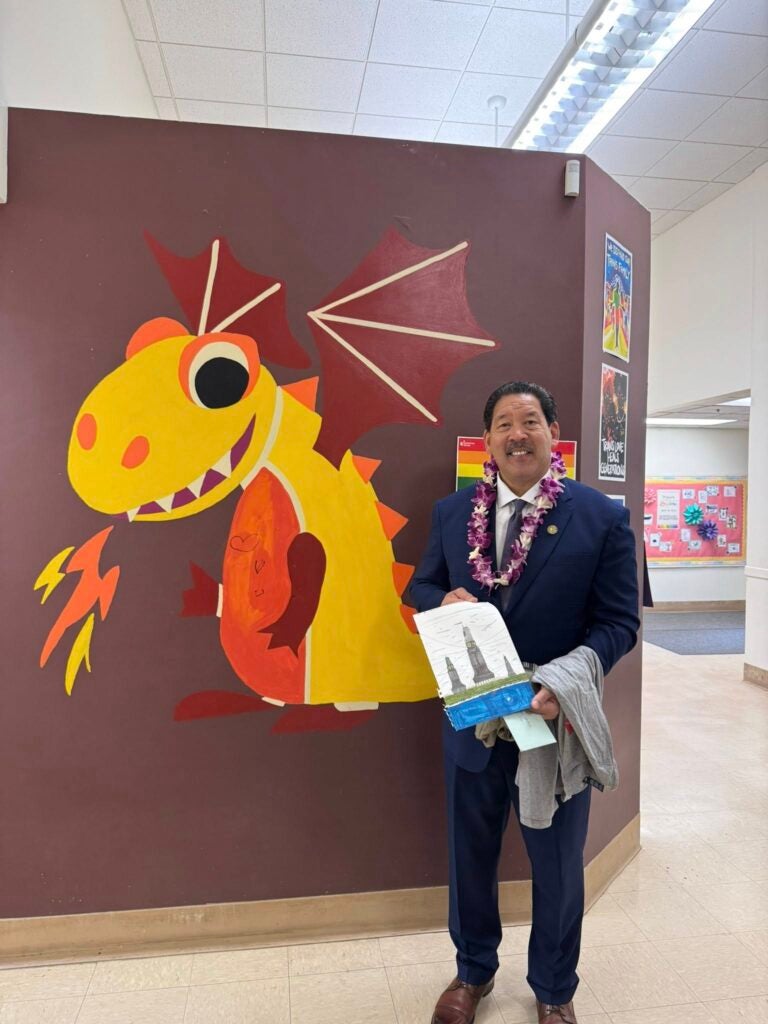 Mayor Harrell in front of B.F. Day Dragon on wall.