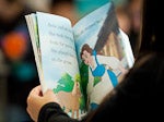looking over someone's shoulder while they read a picture book