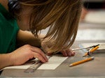 a student working with a ruler and pencils