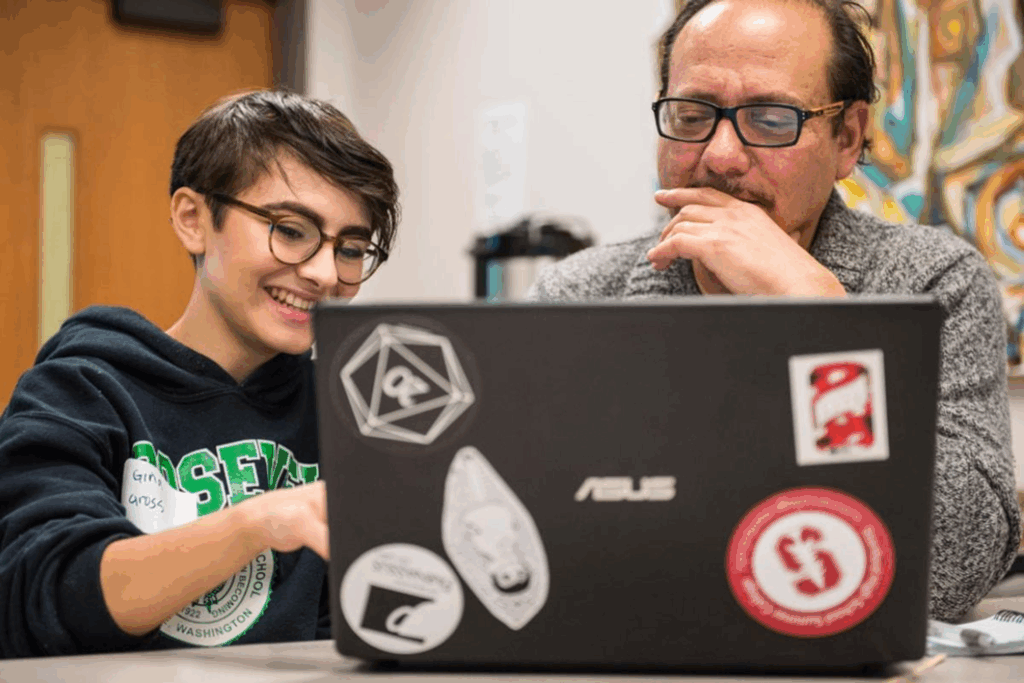 Picture of a Robinson Center student studying on a computer with a UW professor