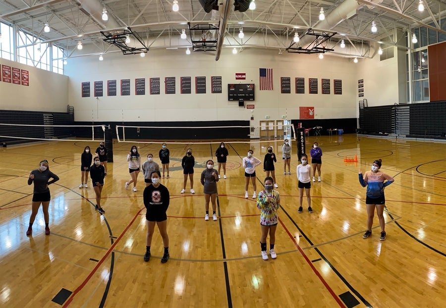 Cleveland volleyball team in the gym with masks on