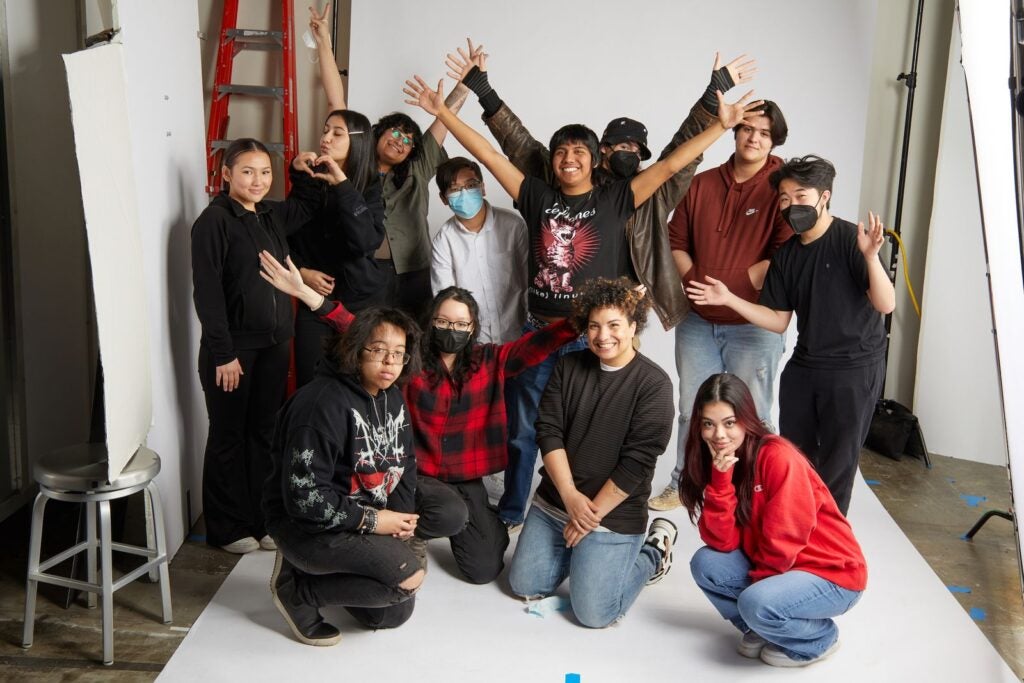 Students from last year's cohort celebrating their success in front of the standard white photographer's backdrop