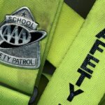 a neon green belt with a silver safety patrol badge