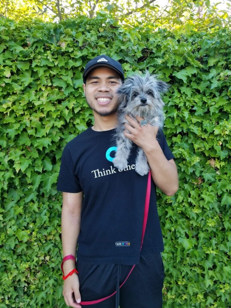 Photo of Sidney Lim with small dog on his shoulder