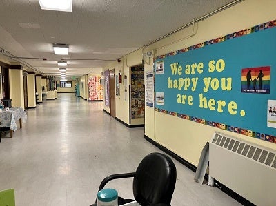 hallway at lowell with a sign that says "we are so happy you are here."