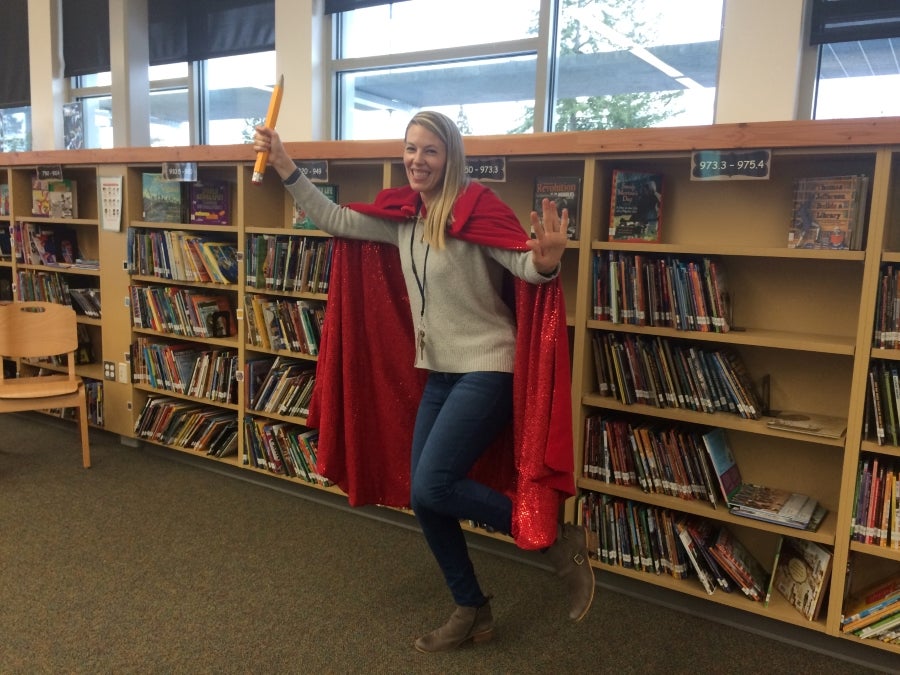 Librarian Jessica Lindow in the library wearing a cape