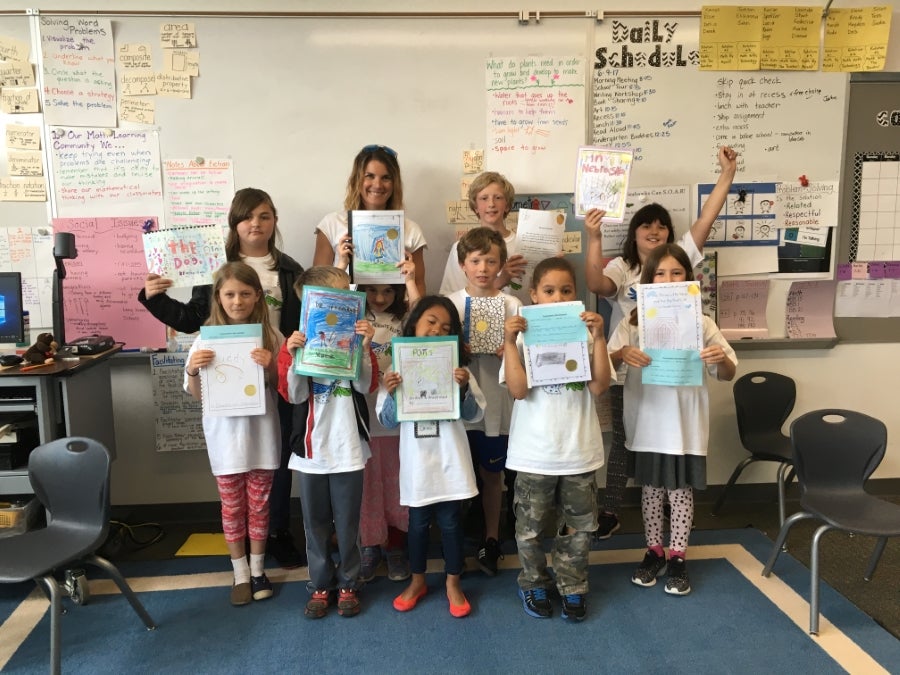 Students holding up their books created on Young Author's Day