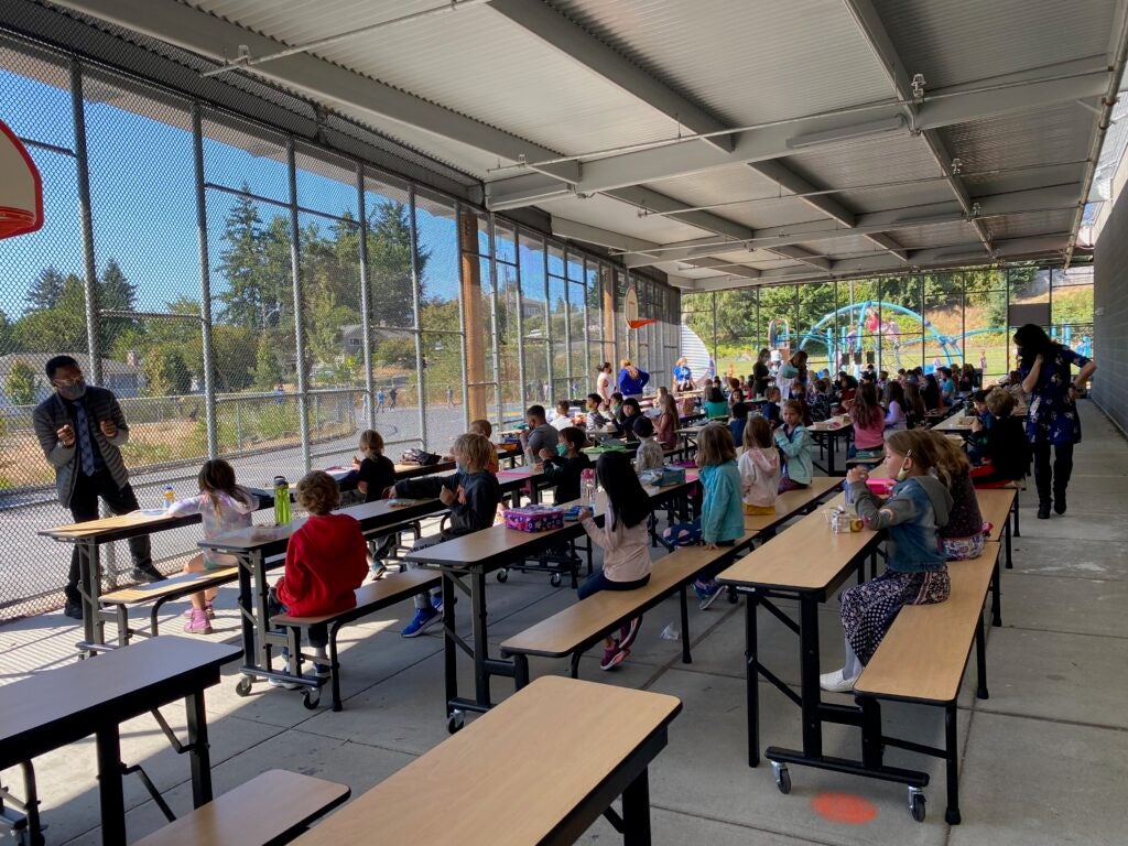 Students eating lunch in outside covered play court