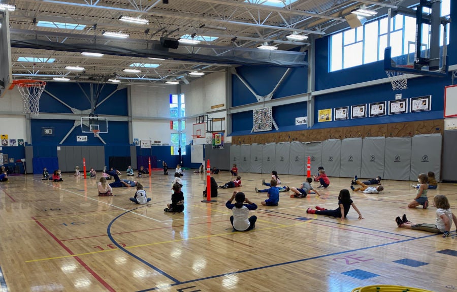 students stretching in the gym during P.E. class