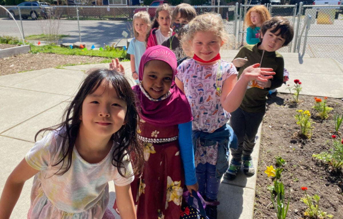 group of kindergartner students outside in school garden