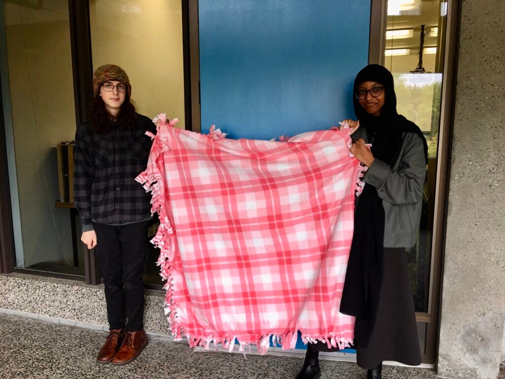 Students holding a tie blanket.