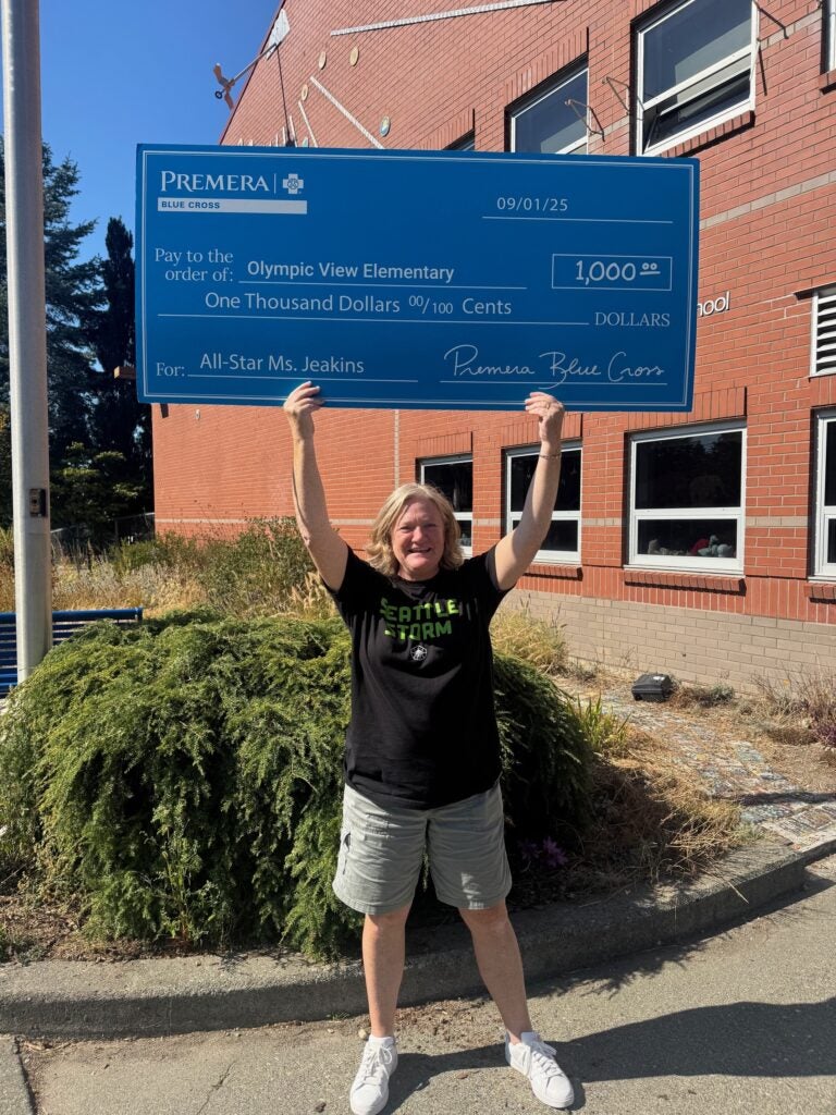 Jill Jeakins in front of Olympic View with a $1000 check from Premera and the Seattle Storm