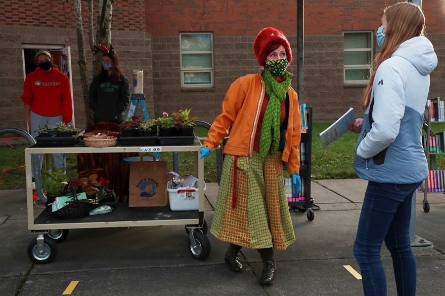 India Carlson, who teaches botany and environmental horticulture at Ballard High School, gives plants to students during a curbside pickup event at the school Dec. 10. (Erika Schultz / The Seattle Times)