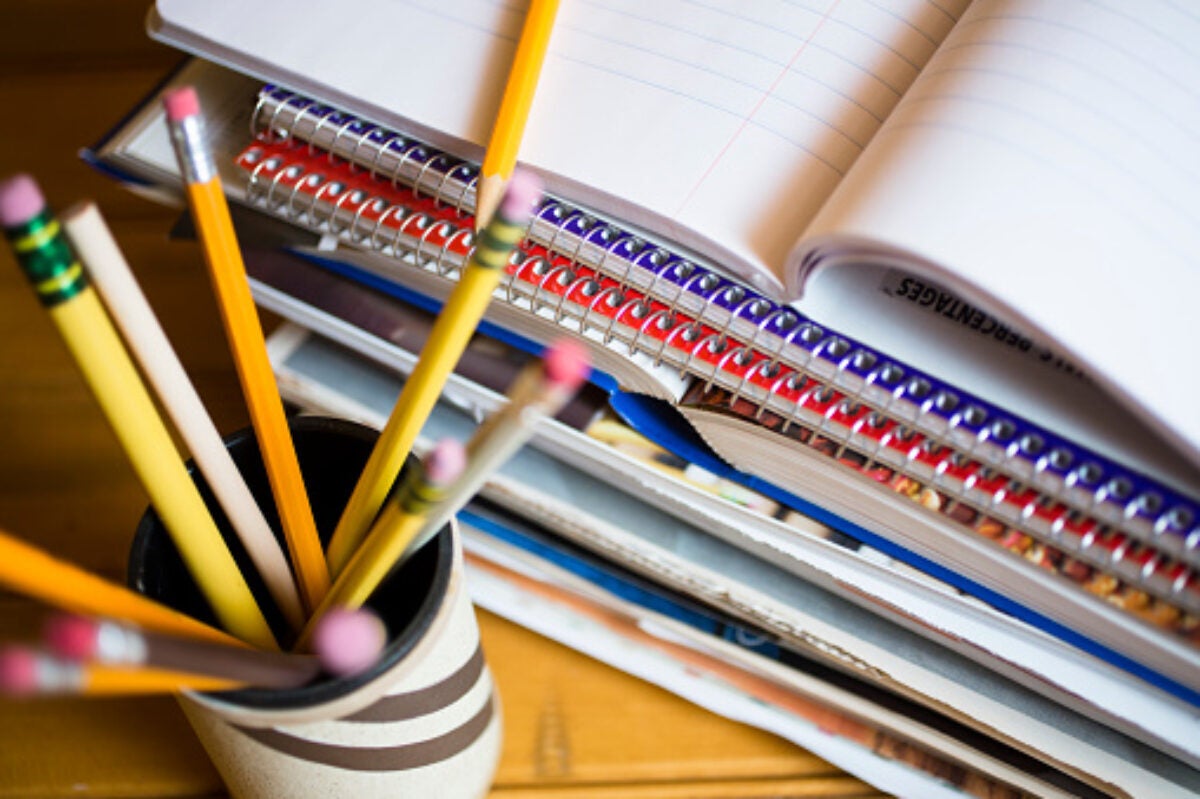 Jar of pencils and stack of notebooks