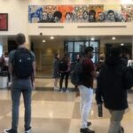 Students in landing on 2nd floor under the Mural