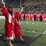 Students in red cap and gown at Memorial Stadium