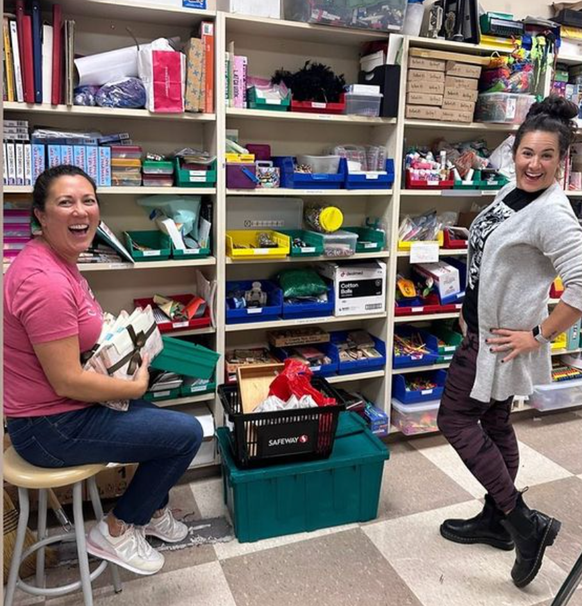 Parent Volunteers in the BHS Library by shelves of supplies.