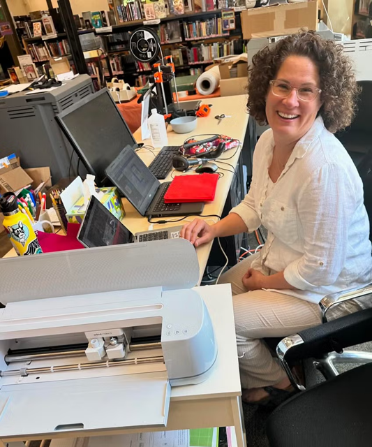 Volunteer at computer in the library.